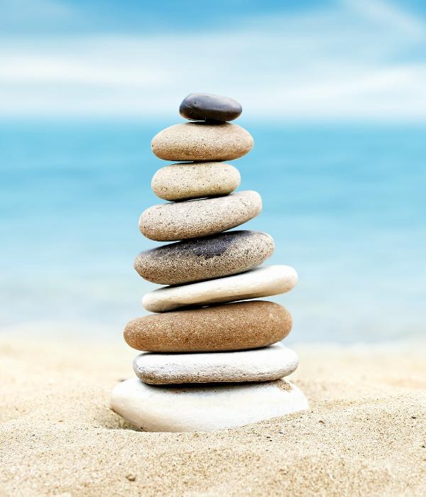 Feng shui piled rocks in sand at beach