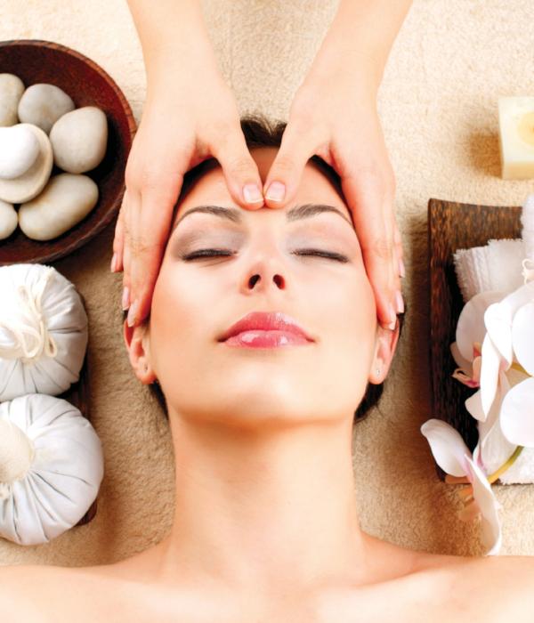 Head of woman receiving beauty and wellness treatment head massage