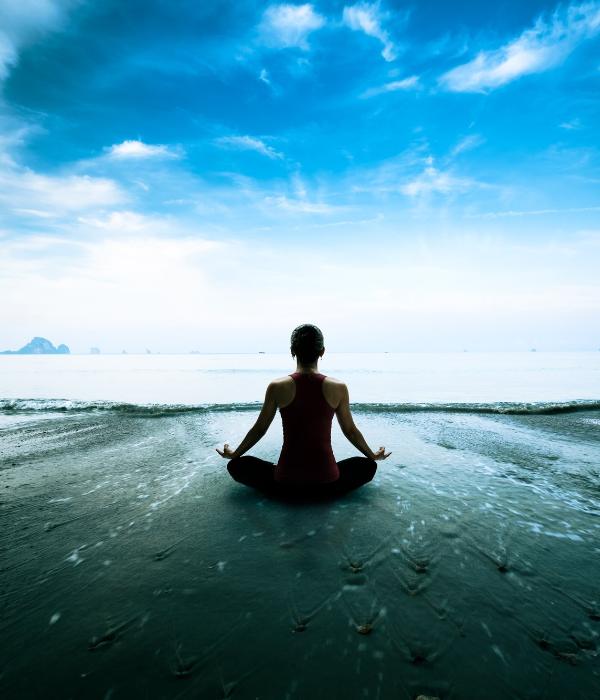 Woman meditating by the ocean