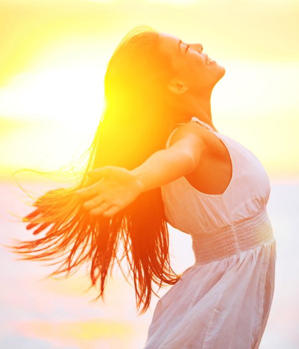 A young woman smiles while enjoying the sunset